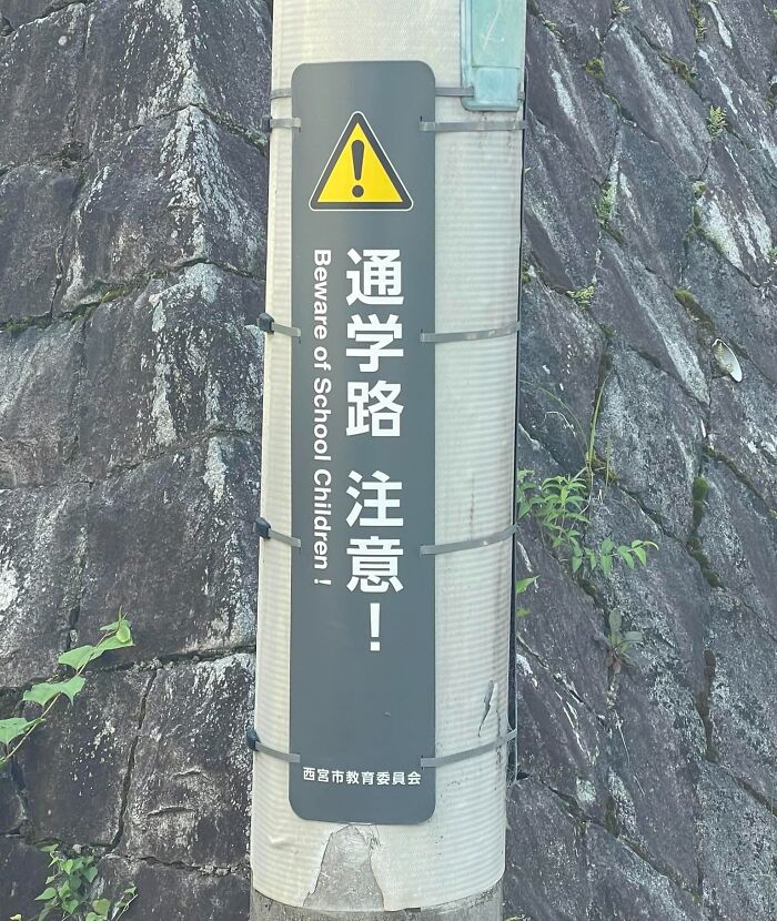 Warning sign on a pole with a humorous example of Japan getting lost while translating to English.
