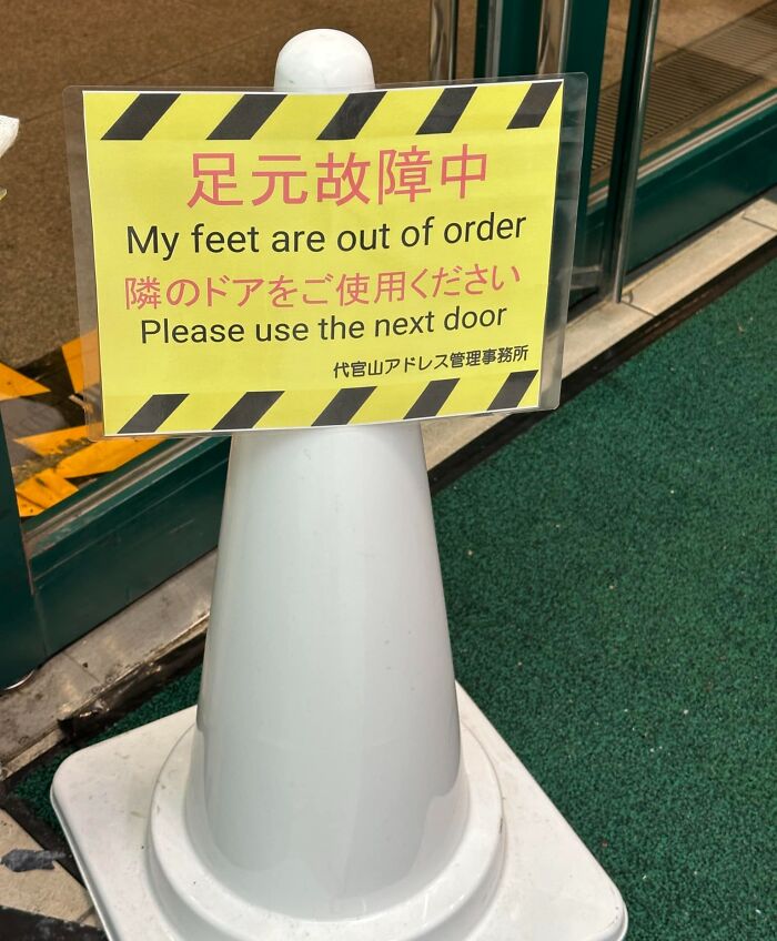 Yellow caution sign on white cone with funny English translation about feet being out of order in Japan translation fails.