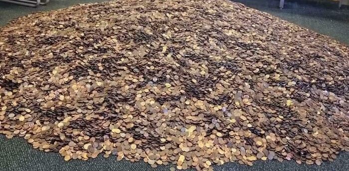 Amazing Photos showing a massive pile of pennies covering carpeted floor, creating a textured bronze mound