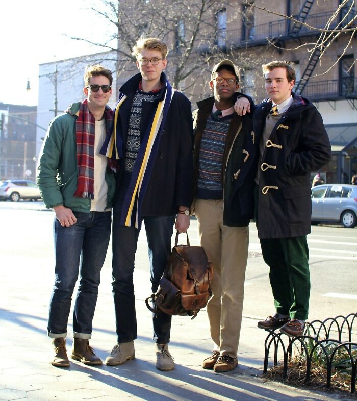 Group of tall young men standing outdoors on a city street, showcasing height differences and fashion styles typical of tall people.