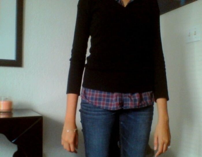 Tall person standing indoors wearing a black sweater and jeans, illustrating struggles only tall people face shared online