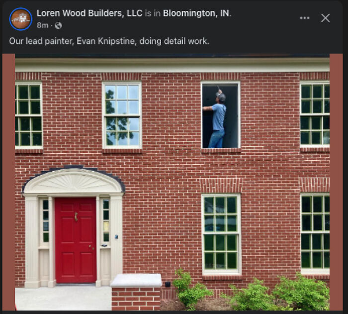 Painter working on window frame of a brick building exterior in a surprising and unhinged home renovation moment