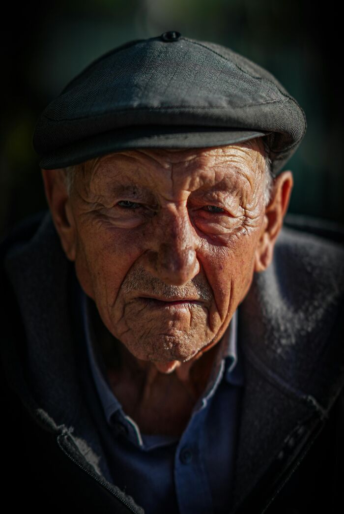Elderly man wearing a cap with deep wrinkles, symbolizing the emotional weight of family secrets shared by many people.