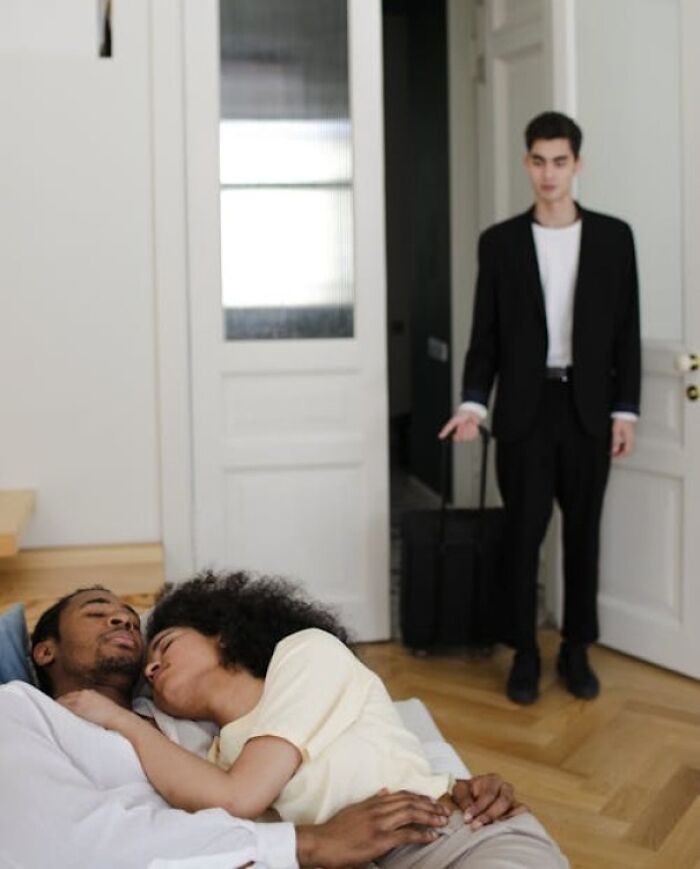 A man stands at the door with a suitcase as a couple lies on a bed, hinting at hidden family secrets and tension.