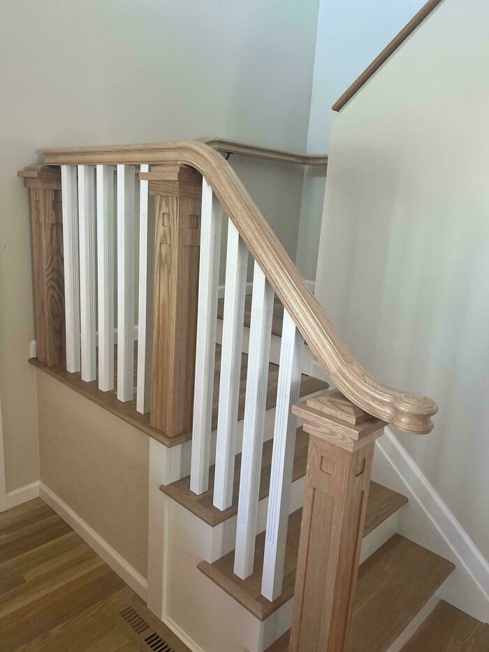 Wooden staircase with white balusters showing a dumb design decision creating problems in home decor and construction.