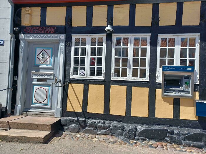 ATM awkwardly installed in a historic building facade, showcasing dumb design decisions creating problems nobody asked for.