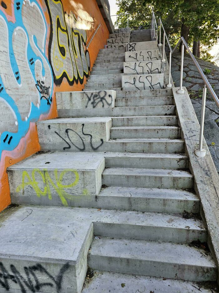 Concrete stairs with uneven steps and graffiti showcasing dumb design decisions creating problems in public spaces