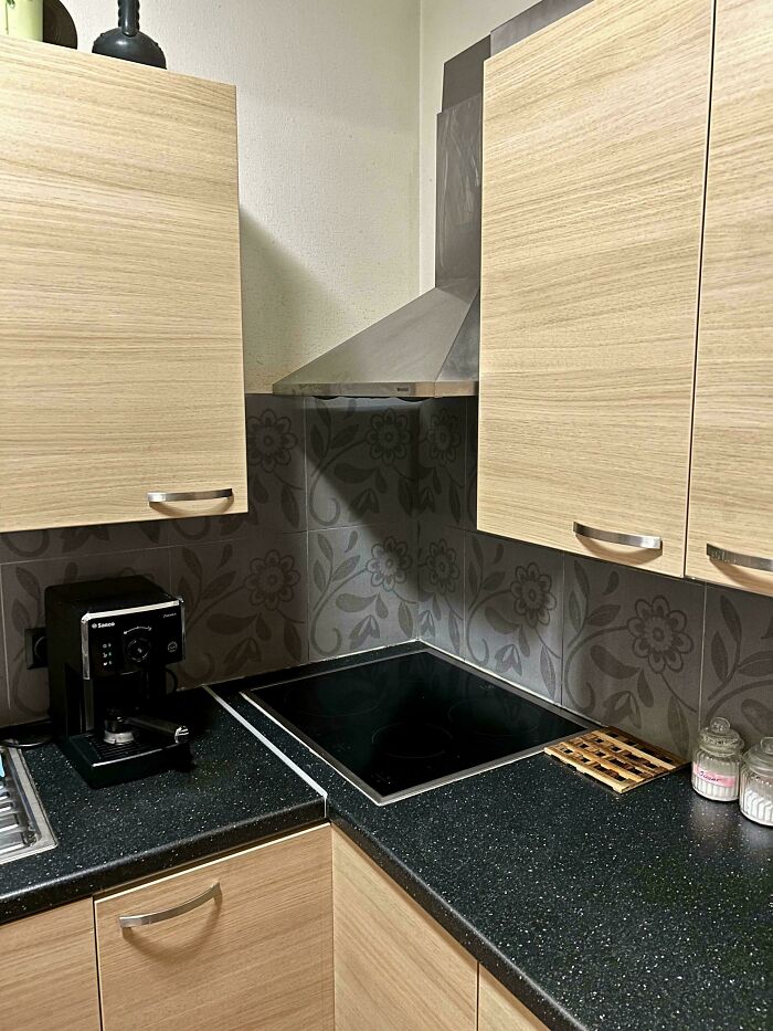 Kitchen corner with stovetop and cabinets showing design decisions that create problems nobody asked for.