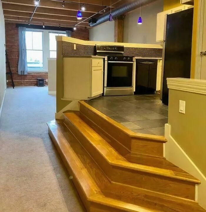 Kitchen design with oddly shaped steps leading up to elevated cooking area showing dumb design decisions.