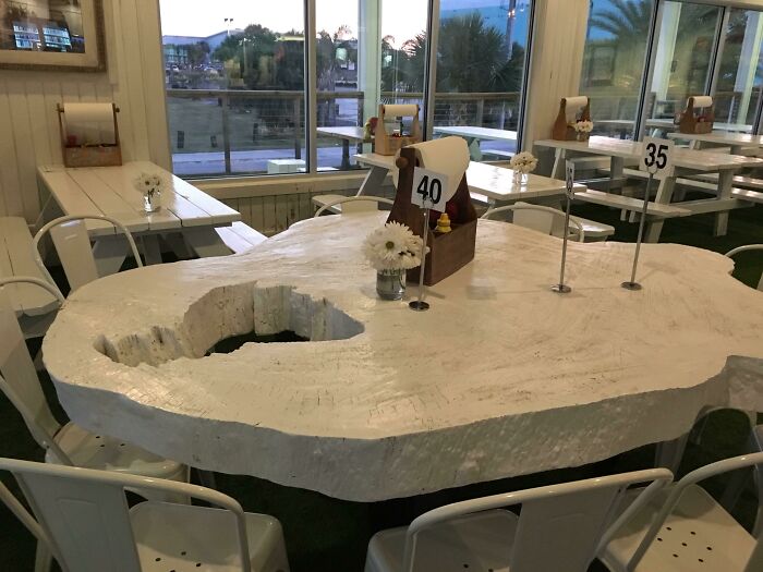 Unusual dining table with a large hole in the center showing one of the dumb design decisions by designers.
