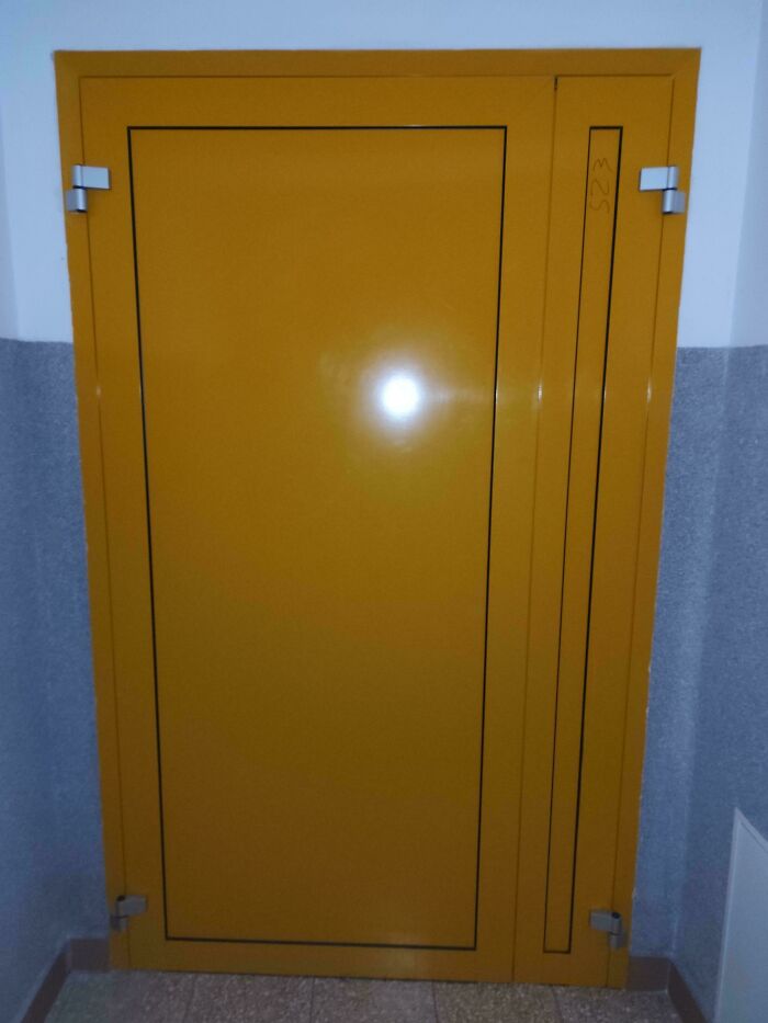 Yellow door with confusing handle design highlighting dumb decisions by designers creating problems nobody asked for.