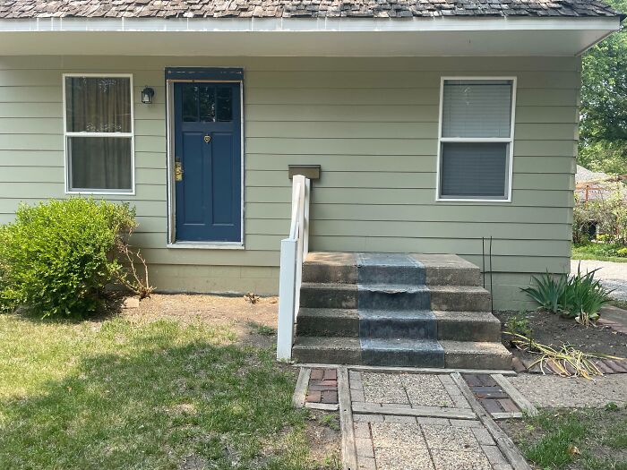 House with stairs leading to a raised door, showcasing a design mistake and dumb decision by designers causing access problems