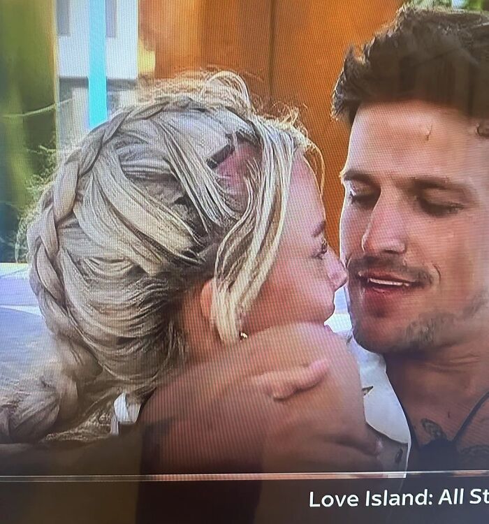 Close-up of a woman with a messy braided hairstyle and a man smiling, showcasing a disastrous hairstyle moment.