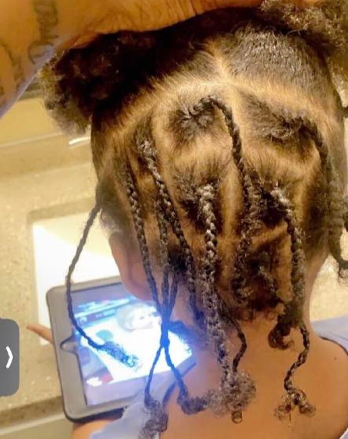 Child with a series of uneven and messy braids viewed from the back, showcasing one of the disastrous hairstyles.