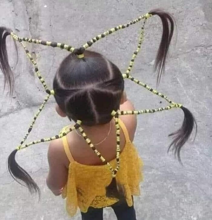 Child with a unique and intricate hairstyle featuring braided sections extending outward, a prime example of disastrous hairstyles.
