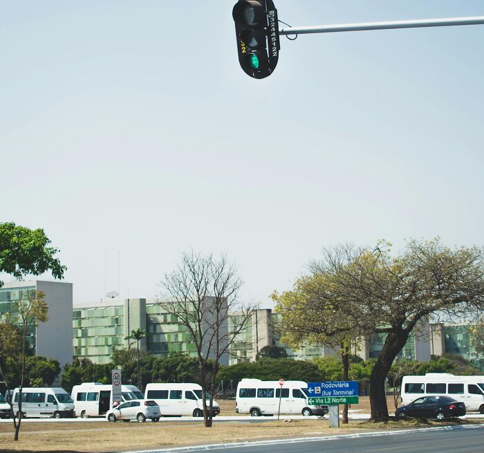 Urban street scene with traffic lights and vehicles, reflecting out of pocket rich people comments on living costs.
