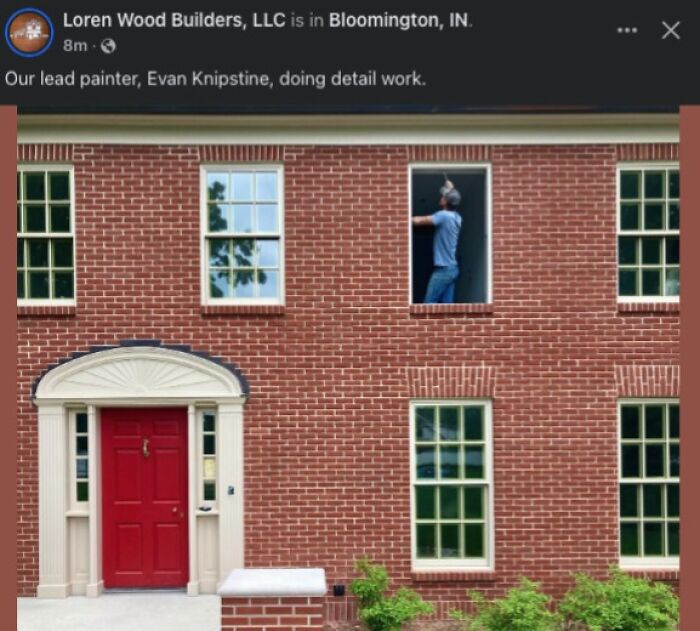 Painter working on window frame of a brick building exterior in a surprising and unhinged home renovation moment