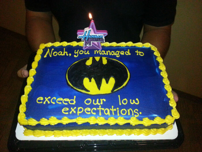 Funny cake with Batman logo and sarcastic message, reflecting honest emotions and humor in cake designs.
