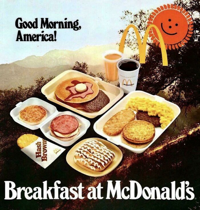 Vintage advertisement showing a McDonald's breakfast tray with pancakes, eggs, hash browns, coffee, and a smiling sun logo.
