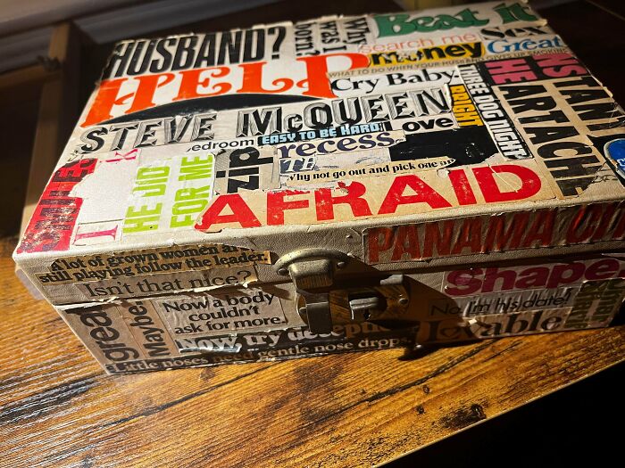 Vintage advertisements collage on a small suitcase, featuring bold typography and retro-style phrases in various colors.