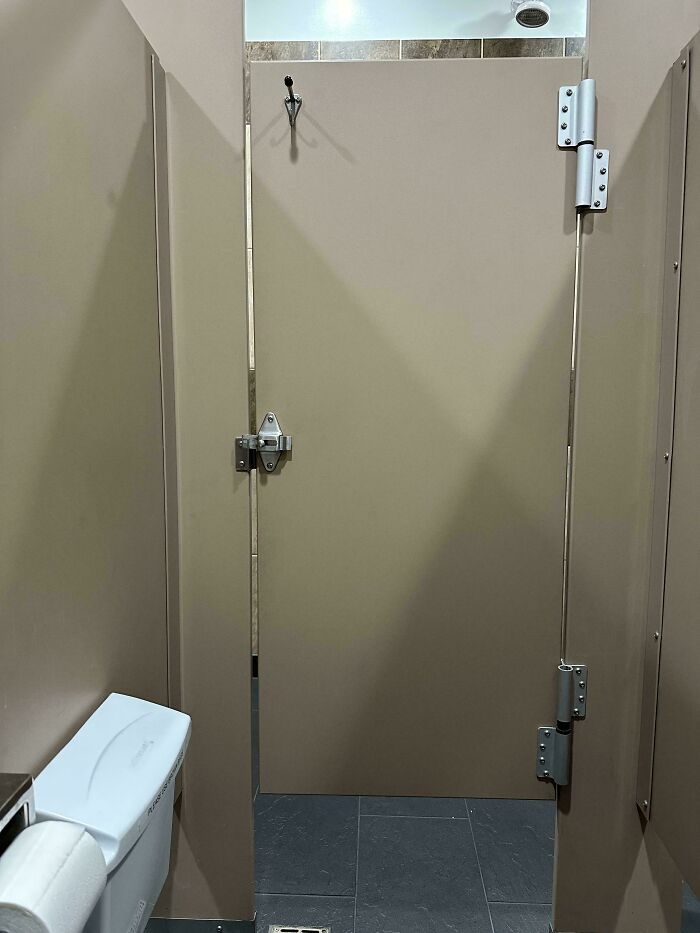 Public bathroom stall with gap below door showcasing normal practices in Europe that the US may find weird.