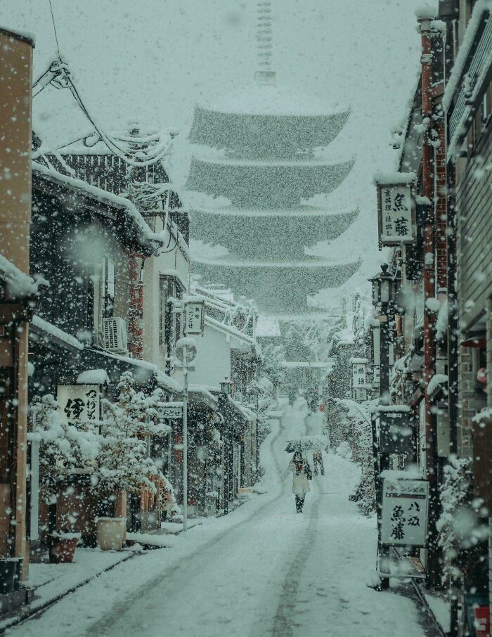 Snow-covered traditional street with a pagoda in the background, perfect for cozy winter images this year.