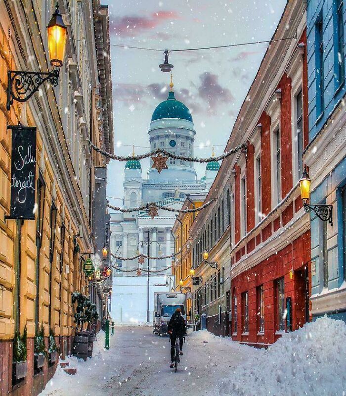 Snowy winter street with colorful buildings and festive decorations featuring cozy winter scene without stepping into cold.