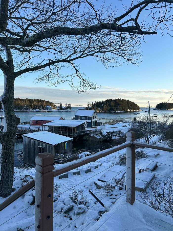 Snow-covered coastal village with cozy cabins and calm water, perfect for enjoying winter without stepping into the cold.