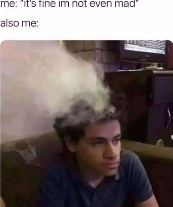 Young man sitting with smoke coming out of his head, illustrating a relatable introvert meme about hidden emotions and thoughts.