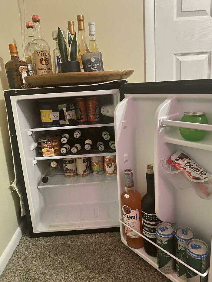 Mini fridge stocked with various beverages and snacks, illustrating normal practices in Europe that may seem unusual in the US.