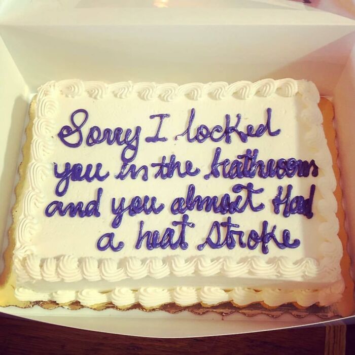 Rectangular white cake with purple text humorously apologizing for locking someone in the heat room, a funny cake photo.