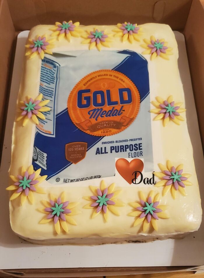 Cake decorated with a Gold Medal flour bag image and yellow flowers, reflecting funny cakes with honest emotions.