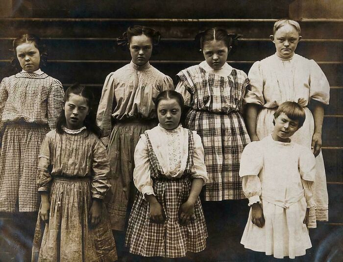 Group of Victorian era children standing in old-fashioned clothing, illustrating the different time period and historic lifestyle.