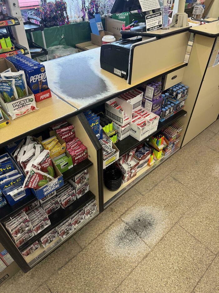 Worn down countertop and floor at a convenience store checkout showing everyday objects' wear in unexpected ways
