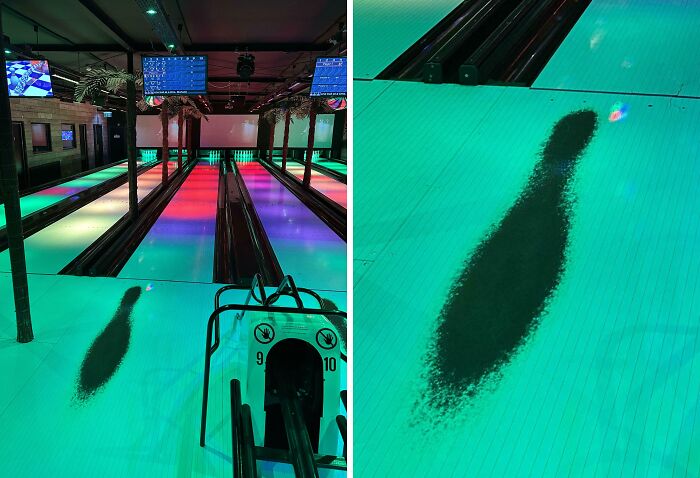 Worn down bowling lane showing a polished, darkened area from repeated use and ball impact over time.