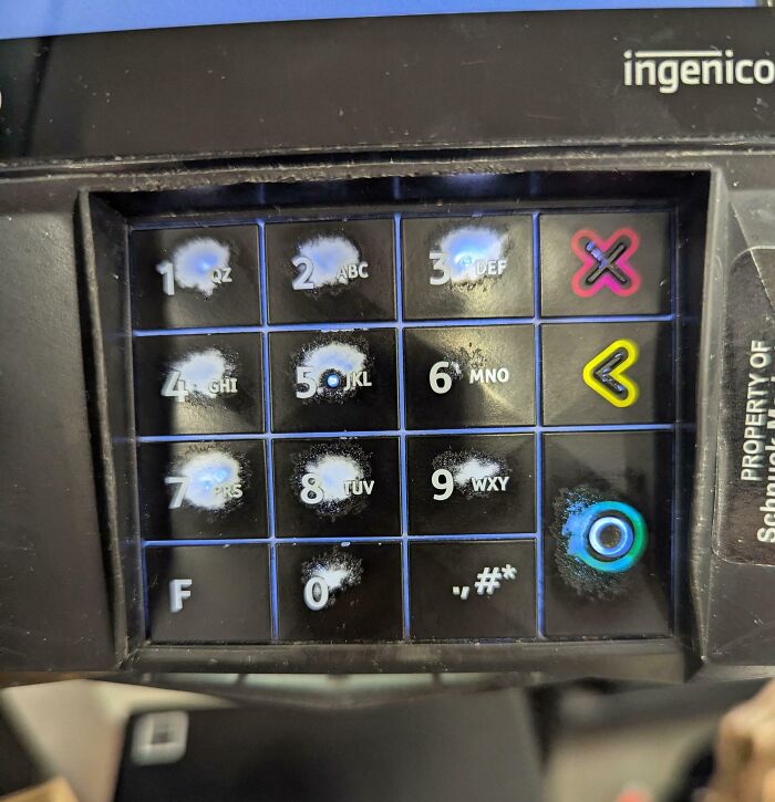 Worn down keypad buttons on an Ingenico payment terminal showing signs of heavy everyday use.