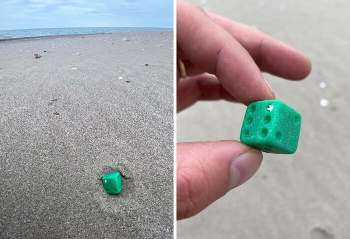Green plastic dice worn down in unexpected ways found on a sandy beach shore.