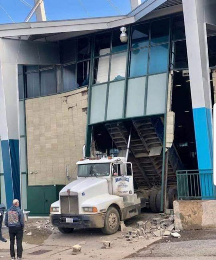 White dump truck crashed into building causing extensive damage, illustrating one of the expensive unfortunate fails.