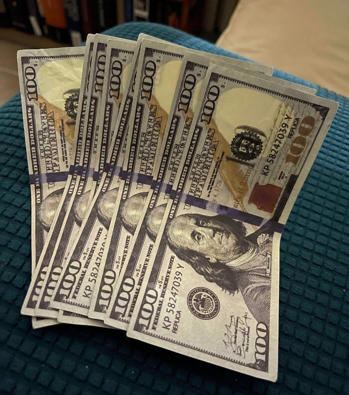 Several $100 bills laid out on a blue textured surface, representing expensive fails in money-related mistakes.