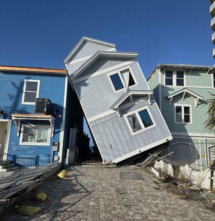 Tilted house collapsed between two buildings showing an expensive fail and unfortunate structural mistake outdoors.