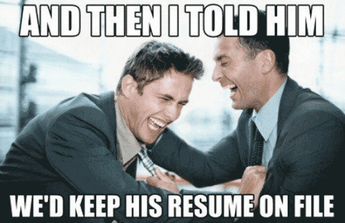 Two men in suits laughing together, sharing a funny moment about keeping a resume on file, resume memes theme.