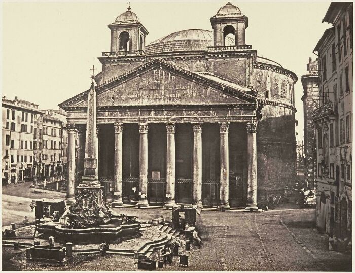 Historic site photo of ancient Roman building with columns and a fountain in front, showcasing classic architecture.