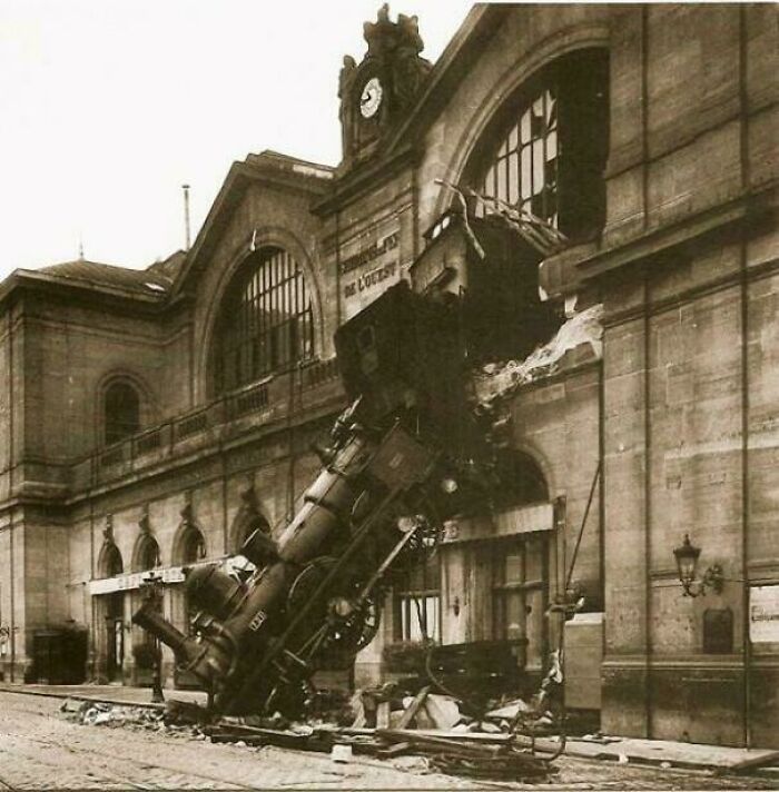 Historic site photo showing a vintage train crashed into a building, illustrating history repeated with dramatic impact.