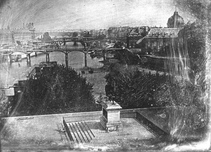 Historic site photo showing an old cityscape with bridges and river, capturing history repeated in a timeless urban scene.