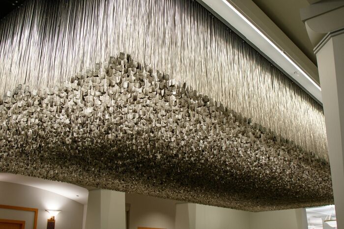 Ceiling display of suspended dog tags in a historic site museum, illustrating poignant moments from history repeated.