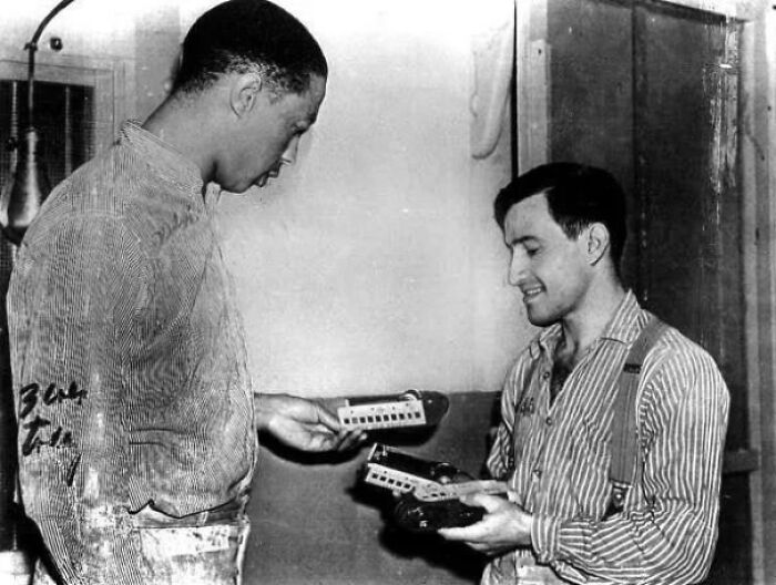 Two men examining shoes with metal plates in a historic setting showcasing fascinating historic site artifacts.