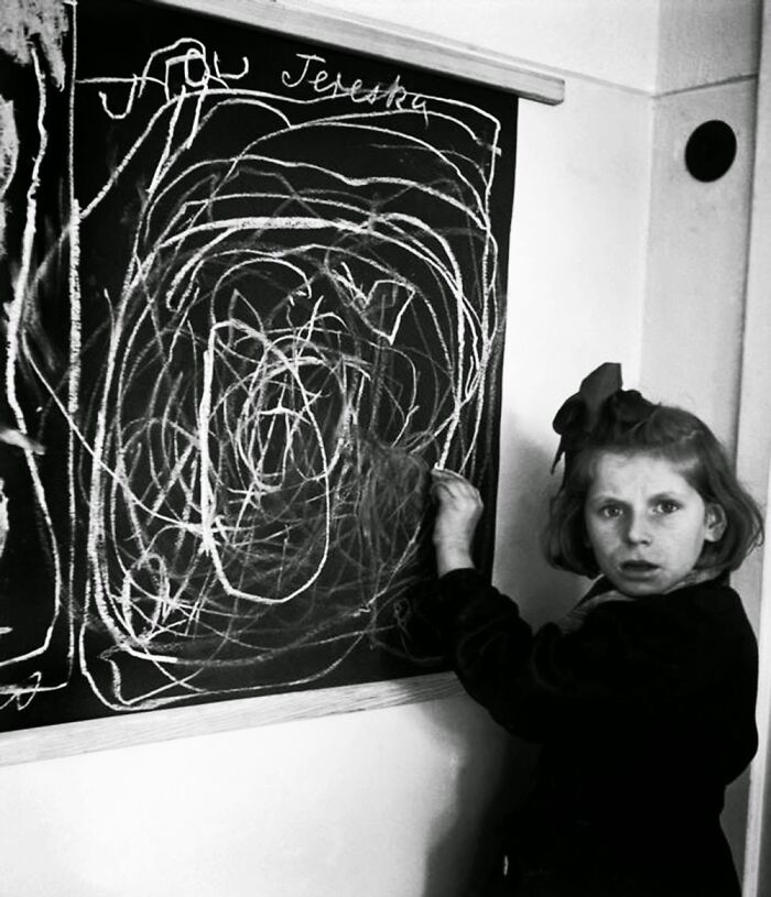 Young girl drawing on a chalkboard at a historic site, showcasing fascinating history repeated through past education.