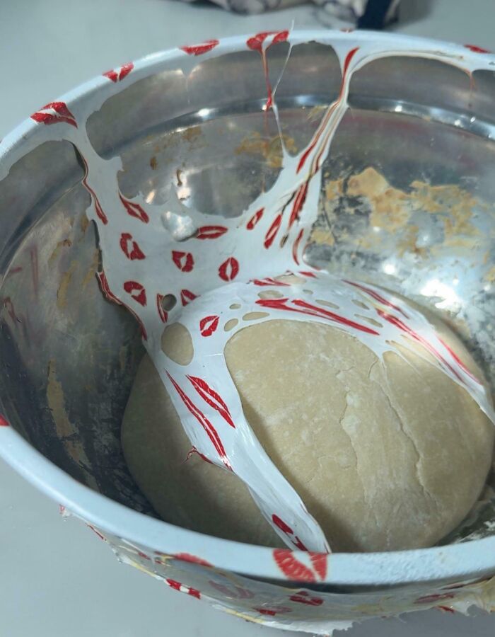 Sticky dessert batter stuck to a metal bowl with red lip print patterns, showing a common dessert ruin mishap.