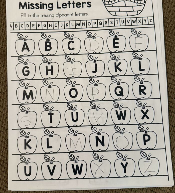 Missing letters worksheet filled with alphabet letters inside apple shapes, showing design mistakes and handwriting errors.