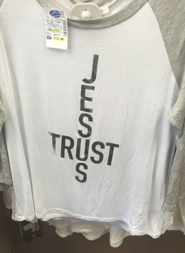 White and gray raglan shirt with a failed design spelling JESUS and TRUST in a confusing layout on the front.